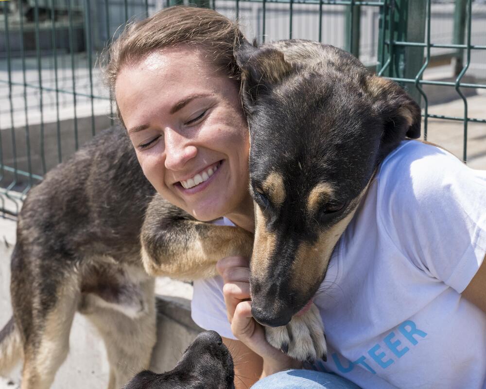 smiley-woman-playing-with-cute-dog-up-adoption (1)